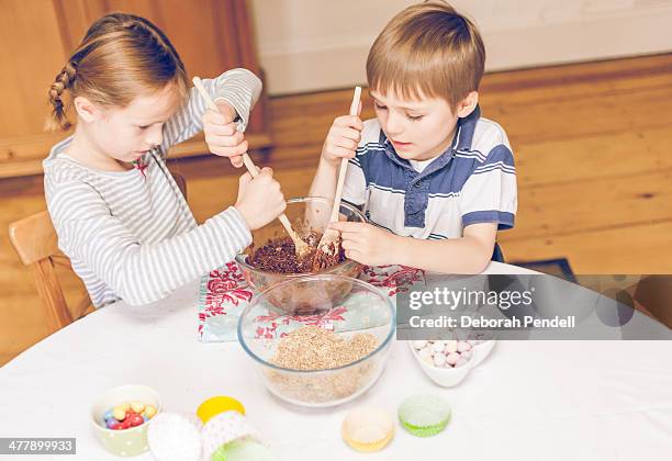 girl and boy stirring chocolate cake mixture - cake batter stock pictures, royalty-free photos & images