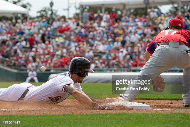 Jordan Schafer of the Atlanta Braves slides safely into third base ahead of the tag from Reid Brignac of the Philadelphia Phillies after hitting a 2...