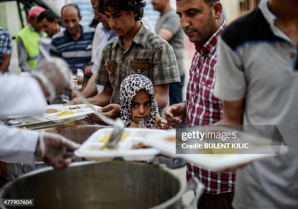 Syrians break their fasting on June 20, 2015 in Akcakale, in Sanliurfa province, during the holy month of Ramadan. The UN's refugee agency marked...
