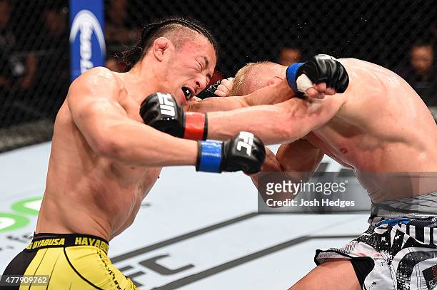Tatsuya Kawajiri of Japan punches Dennis Siver of Germany in their featherweight bout during the UFC Fight Night event at the O2 World on June 20,...