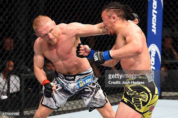 Dennis Siver of Germany punches Tatsuya Kawajiri of Japan in their featherweight bout during the UFC Fight Night event at the O2 World on June 20,...