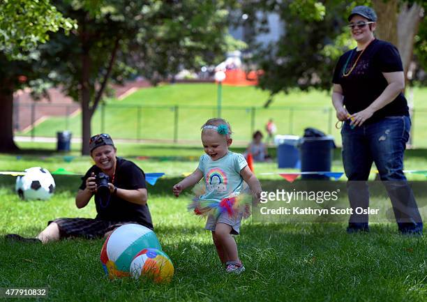 Jensen, left, and Amanda McCombs, right, watch and take photos of their daughter Nova as she plays with several beach balls in the family area of the...