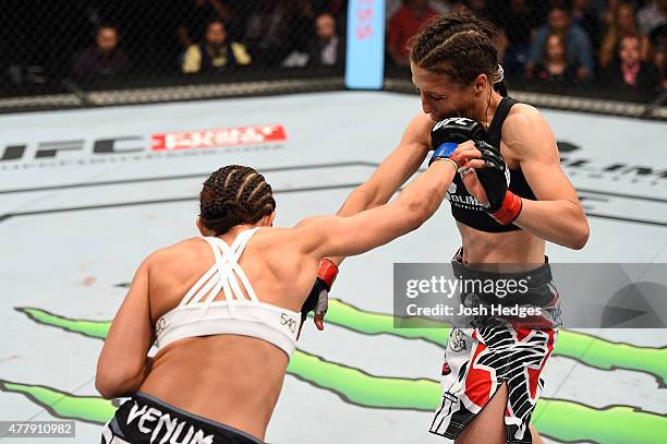 Jessica Penne of the United States punches Joanna Jedrzejczyk of Poland in their women's strawweight championship bout during the UFC Fight Night...