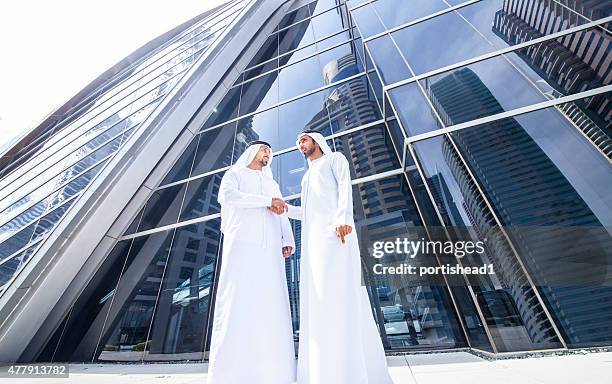 arab  businessmen in traditional clothes in front of modern building - traditional clothing stock pictures, royalty-free photos & images