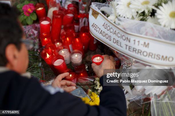 Woman places a candle for the victims of Madrid train bombings at a memorial monument at Santa Eugenia train station during the 10th anniversary on...