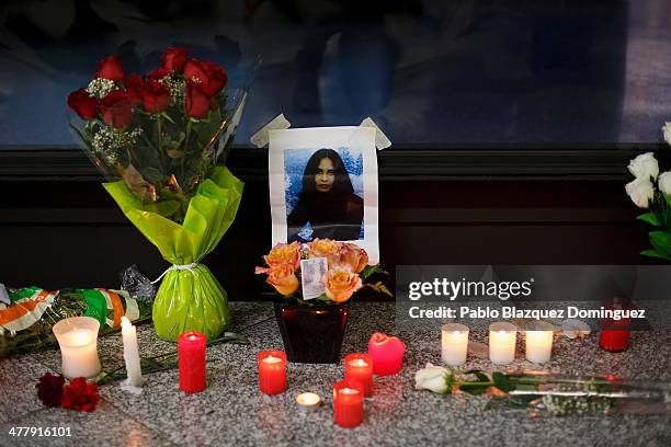 Picture of a woman on display next to candles, letters and flowers placed for the victims of Madrid train bombings outside a memorial monument at...