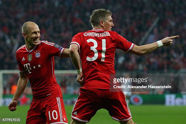 Bastian Schweinsteiger of Muenchen celebrates scoring the opening goal with his team mate Arjen Robben during the UEFA Champions League Round of 16...