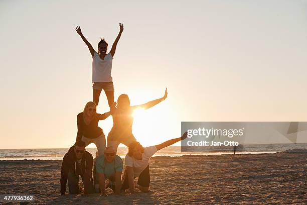 amigos haciendo la pirámide en la playa de de san pedro-ording - human pyramid fotografías e imágenes de stock