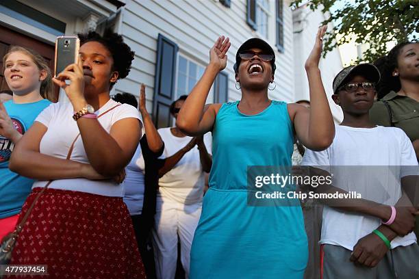 People clap and sing gospel music outside the historic Emanuel African Methodist Church where nine people were shot to death earlier this week June...