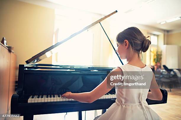 petite fille jouant au piano à queue - soliste photos et images de collection