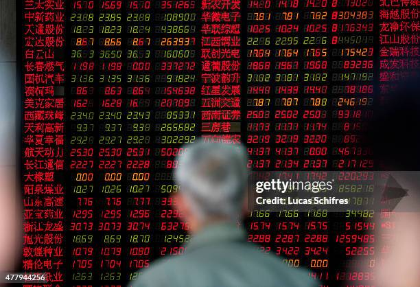 Man in front of a Stock Exchange board in Shenyin and Wanguo Securities' brokerage house , on May 12 in Shanghai, China. In China, home of the...