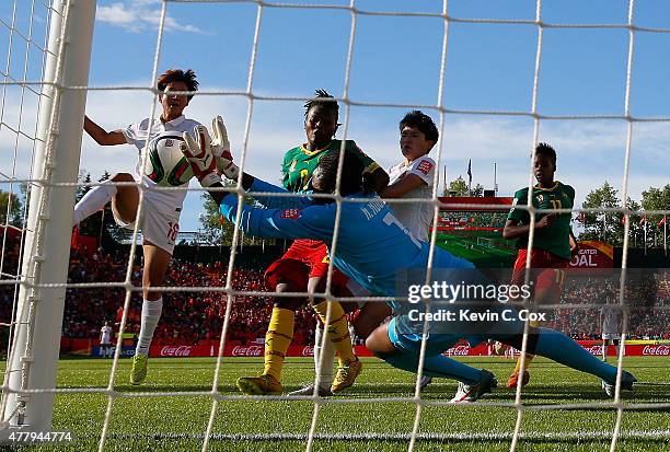 Goalkeeper Annette Ngo Ndom of Cameroon saves a shot on goal against Lou Jiahui of China PR during the FIFA Women's World Canada 2015 Round of 16...