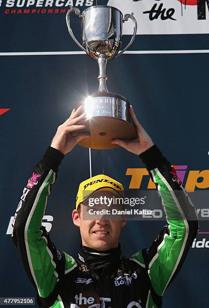 Race winner David Reynolds drives the The Bottle-O Racing Team Ford FG X Falcon holds the winners trophy after race 15 for the V8 Supercars Triple...