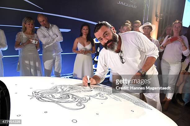 Artist Mauro Bergonzoli paints on the new Jaguar XE during the Jaguar White Night at Wandelhalle Bad Wiessee on June 20, 2015 in Bad Wiessee, Germany.