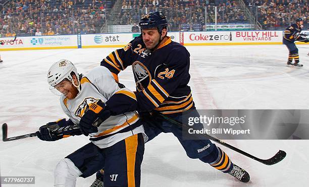 Zenon Konopka of the Buffalo Sabres lays a hit on Ryan Ellis of the Nashville Predators on March 11, 2014 at the First Niagara Center in Buffalo, New...