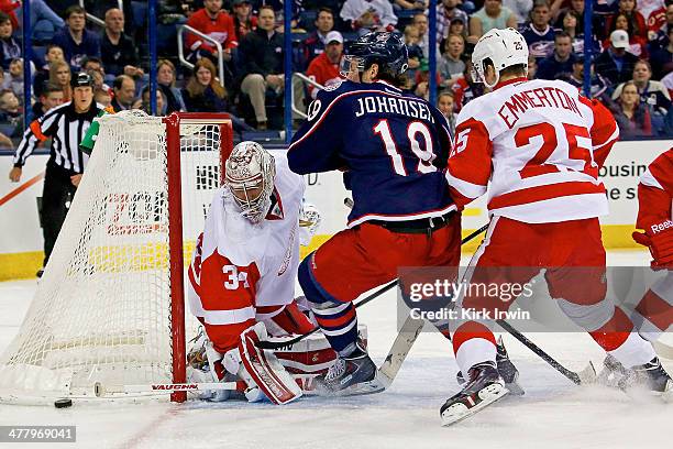 Petr Mrazek of the Detroit Red Wings stops a shot from Ryan Johansen of the Columbus Blue Jackets as Cory Emmerton of the Detroit Red Wings attempts...