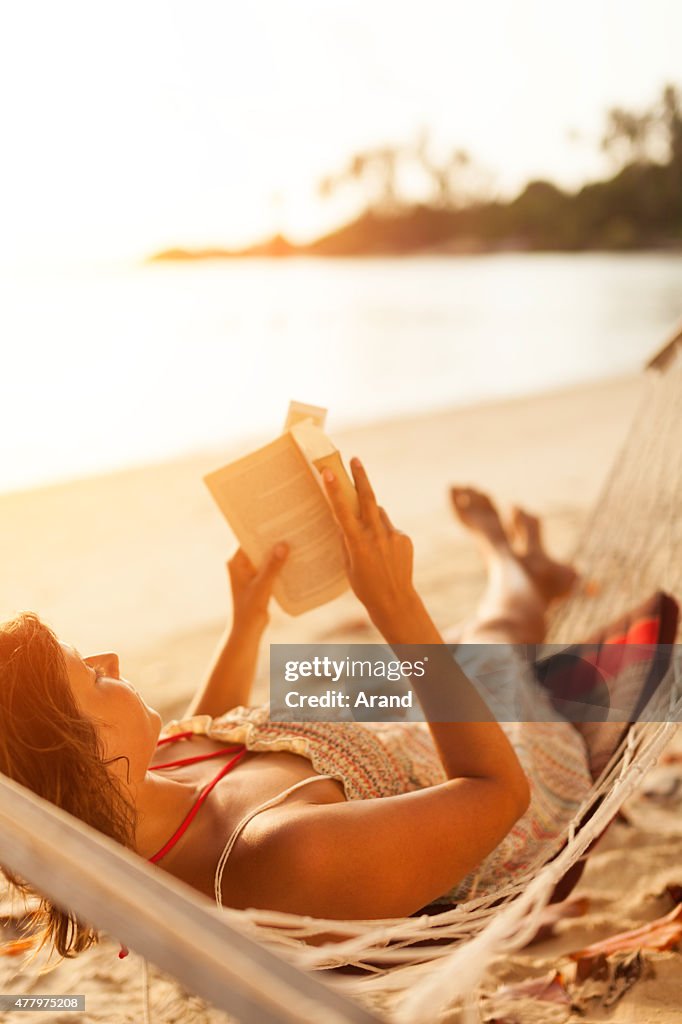 Woman reading book in hammock