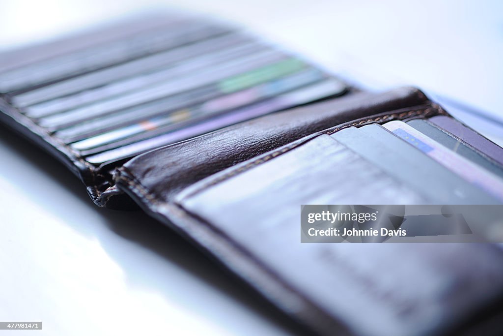 A well used open wallet with credit cards
