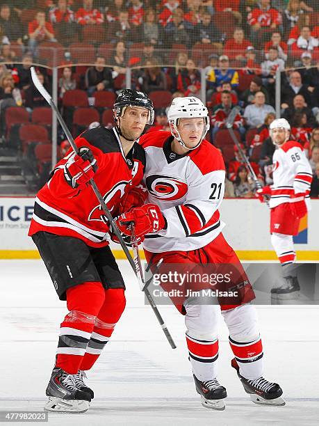 Drayson Bowman of the Carolina Hurricanes in action against Travis Zajac of the New Jersey Devils at the Prudential Center on March 8, 2014 in...