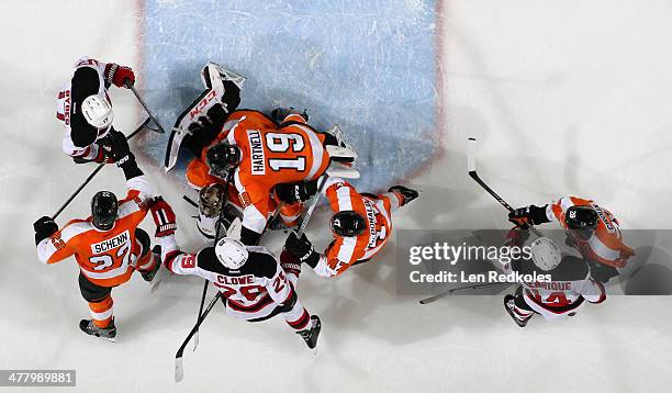 Steve Mason of the Philadelphia Flyers covers the puck as teammates Luke Schenn, Scott Hartnell, Andrew MacDonald and Claude Giroux defend against...