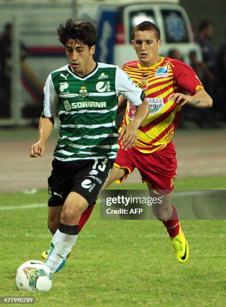 Deportivo Anzoategui of Venezuela Edgar Mendoza vies for the ball with Mexican Santos Javier Abelladuring their Copa Libertadores football match at...