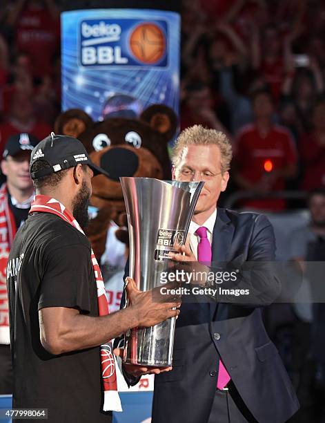 Comissioner Jan Pommer hands over the German basketball trophy to Bradley Wanamaker of Brose Baskets Bamberg after Game Five of the 2015 BBL Finals...
