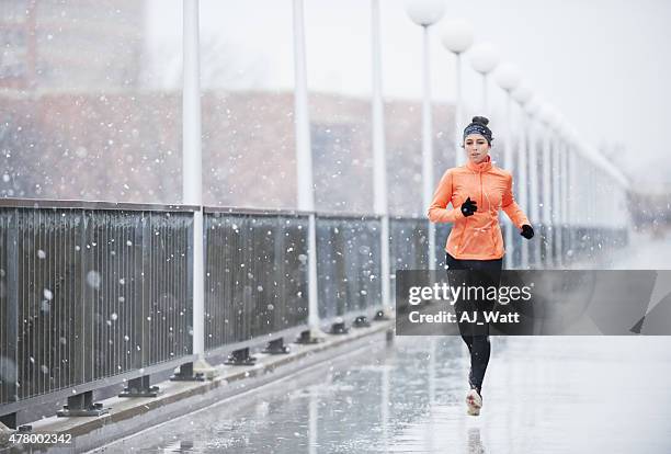 distancer par mauvais temps - jogging winter photos et images de collection