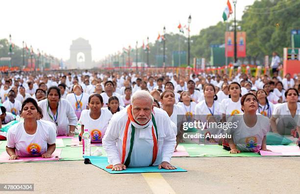 Indian Prime Minister Narendra Modi performs yoga along with others at Rajpath during mass yoga session to mark the International Day of Yoga on June...