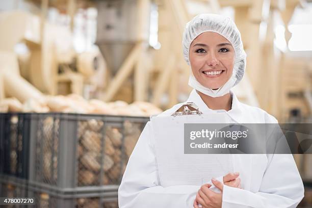 woman  working at a bread factory - haarnet stockfoto's en -beelden