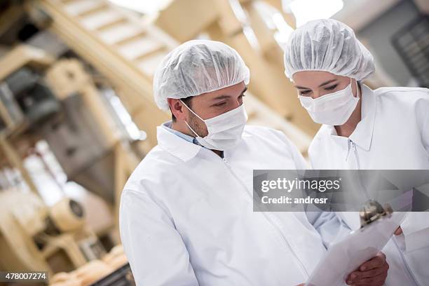 les personnes travaillant dans une usine de  - boulangerie industrielle photos et images de collection