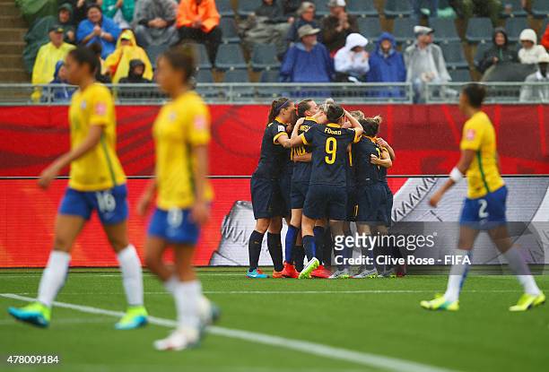 Brazil players look dejected as Kyah Simon of Australia celebrates with team mates as she scores their first goal during the FIFA Women's World Cup...
