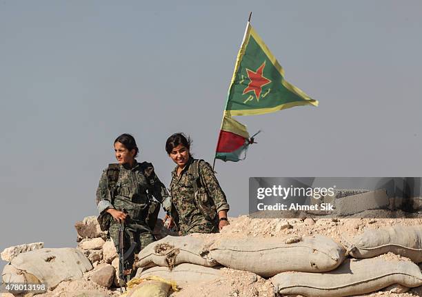 Kurdish People's Protection Units, or YPG women fighters pose as they stand near a check point in the outskirts of the destroyed Syrian town of...