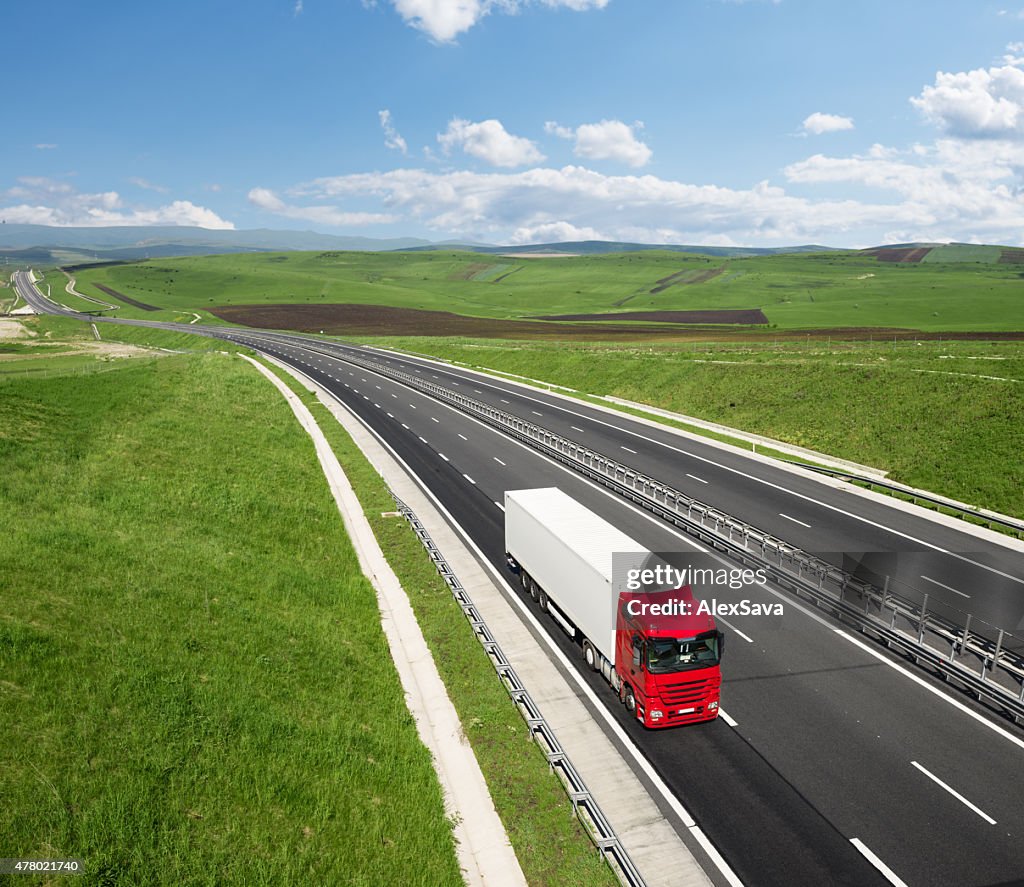 Red and white truck speeding on the highway