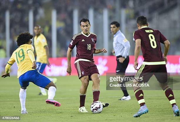 Venezuela's midfielder Juan Arango passes the ball to teammate Tomas Rincon as Brazil's midfielder Willian looks on during the 2015 Copa America...