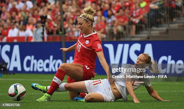 Lara Dickenmann of Switzerland tackles Lauren Sesselmann of Canada during the FIFA Women's World Cup 2015 Round of 16 match between Canada and...