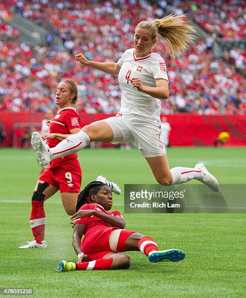 Rachel Rinast of Switzerland jumps over Kadeisha Buchanan of Canada to avoid a collision after losing the ball to Buchanan during the FIFA Women's...