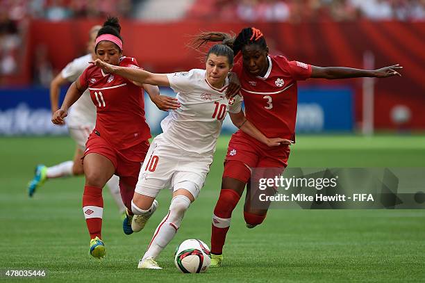 Ramona Bachmann of Switzerland is sandwiched by Desiree Scott and Kadeisha Buchanan of Canada during the FIFA Women's World Cup 2015 Round of 16...