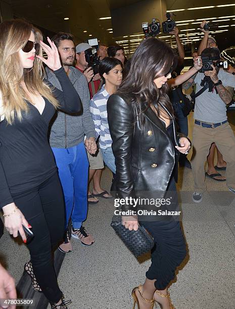 Khloe Kardashian, Scott Disic, Kourtney Kardashian and Kim Kardashian are seen on on March 11, 2014 in Miami Beach, Florida.