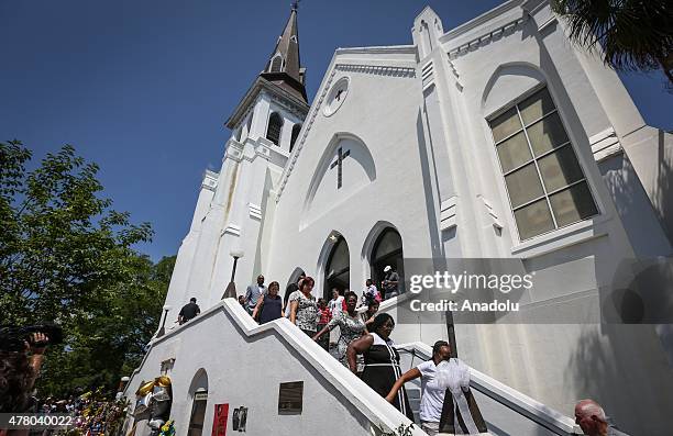 People gather in front of the Emanuel AME Church to attend the first mass after the gunman shooting attack, left nine dead on June 21 in Charleston,...