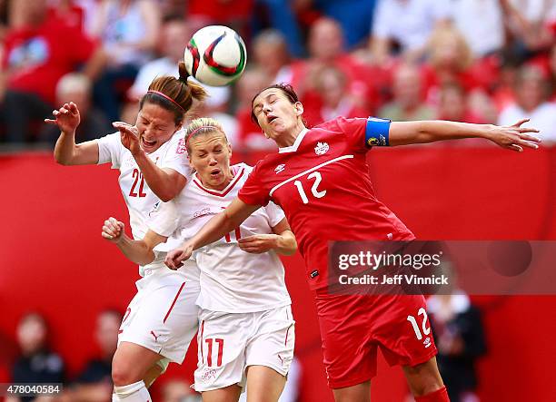 Vanessa Bernauer and Lara Dickenmann of Switzerland and Christine Sinclair of Canada head the ball during the FIFA Women's World Cup Canada 2015...