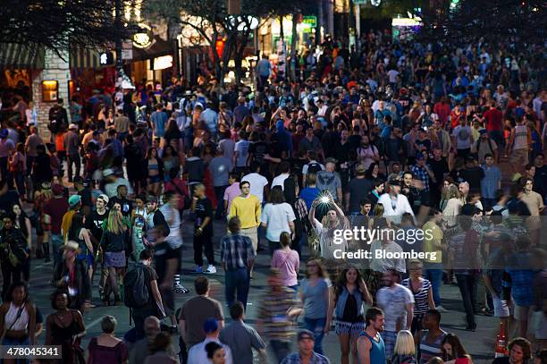 Pedestrian takes a photograph while walking down 6th Street during the South By Southwest Interactive Festival in Austin, Texas, U.S., on Tuesday,...