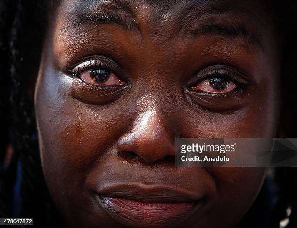Woman cries as the people gather in front of the Emanuel AME Church to attend the first mass after the gunman shooting attack, left nine dead on June...
