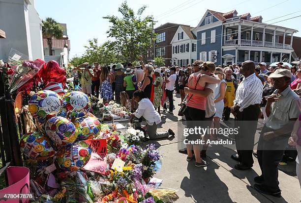 People gather in front of the Emanuel AME Church to attend the first mass after the gunman shooting attack, left nine dead on June 21 in Charleston,...