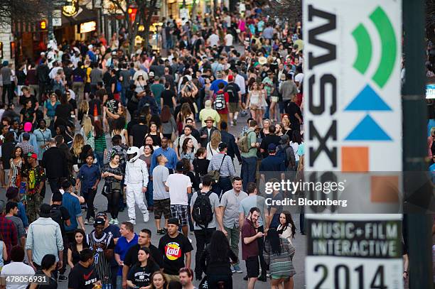 Pedestrians walk down 6th Street during the South By Southwest Interactive Festival in Austin, Texas, U.S., on Tuesday, March 11, 2014. The SXSW...