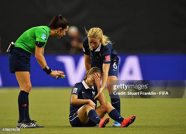 Laure Boulleau of France is helped by Amandine Henry during the FIFA Womens's World Cup round of 16 match between France and Korea at Olympic Stadium...