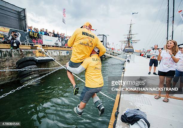 Abu Dhabi Ocean Racing team Justin Slattery of Ireland raises his British skipper Ian Walker to celebrate after arriving in Gothenburg at the end of...