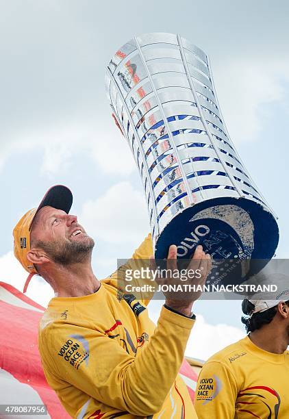 Britain's Ian Walker, skipper of the Abu Dhabi Ocean Racing team, celebrates with the trophy during the winners ceremony after arriving in Gothenburg...