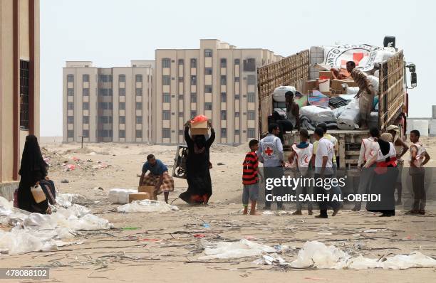 Members of the Yemeni Red Crescent distribute aid to displaced families in the al-Saleh neighbourhood north of the southern Yemeni city of Aden on...