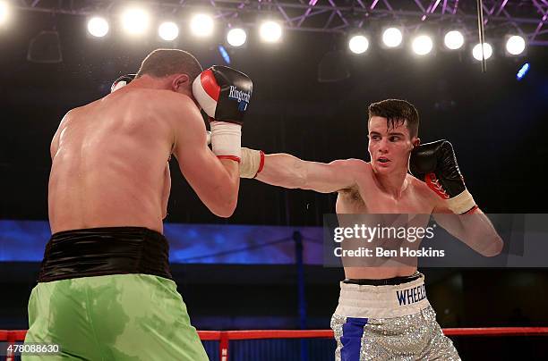 Ryan Wheeler of England and Janis Puksins of Latvia exchange blows during their Super Featherweight bout at Action Indoor Sports Arena on June 13,...