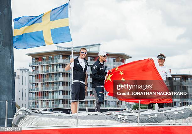 Pit and trimmer Martin Stroemberg of Sweden waves the Swedish flag as Dongfeng Race Team skippered by Charles Caudrelier of France arrives in his...